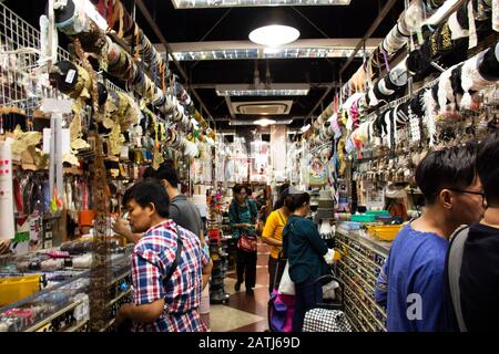 Bangkok, THAILAND - 3. DEZEMBER: Thailändische Leute, die auserwählt gehen und Stoffmaterial mit Accessoires aus dem Bekleidungsgeschäft in Sampeng plaza und Phahura kaufen Stockfoto