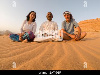 Wadi RUM, JORDANIEN - 19. MAI 2018: Touristen posieren mit ihrem beduinenführer in der Wüste Wadi Rum. Viele beduinen arbeiten jetzt als Leitfäden statt o Stockfoto