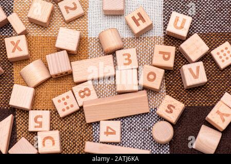 Holzblöcke auf dem Bett mit englischem Alphabet und Symbolen Stockfoto