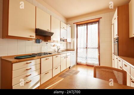 Kücheneinrichtung mit Holztisch an einem sonnigen Tag in normaler Wohnung Stockfoto