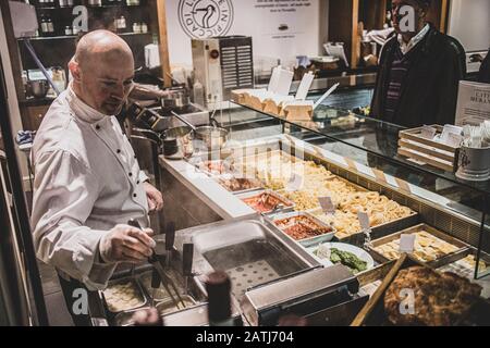 Frischer Nudelkoch, der die wartenden Mittagsarbeiter in Fortnum & Masons serviert. Fortnum & Mason ist ein Upmarket-Kaufhaus in Piccadilly. Stockfoto