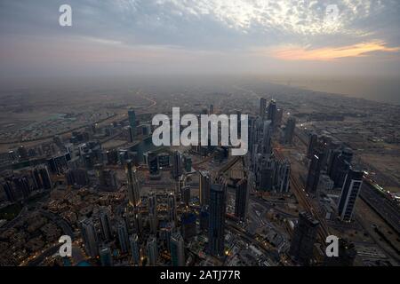 Dubai, VEREINIGTE ARABISCHE EMIRATE - 19. NOVEMBER 2019: Dubai beleuchtete Stadt mit Hochwinkelblick mit Wolkenkratzern am Abend von Burj Khalifa Stockfoto