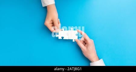 Der Mann und die Frau halten ein Puzzle in der Hand. Geschäftslösungen, Erfolg und Strategiekonzept. Stockfoto