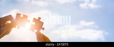 Der Mann hält ein Puzzle in der Hand. Geschäftslösungen, Erfolg und Strategiekonzept. Stockfoto