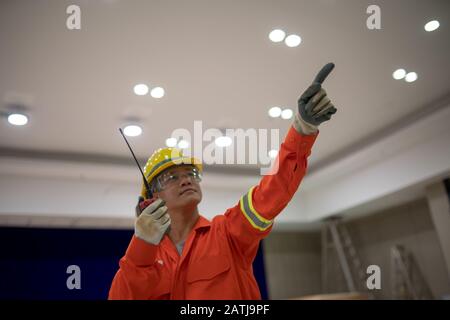 Elektroingenieure arbeiten in der Gebäudeelektrik über Funkkommunikation Stockfoto