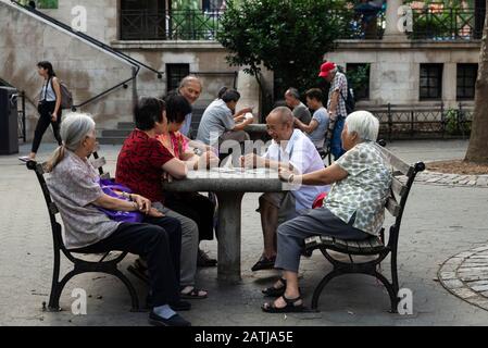 New York City, USA - 2. August 2018: Ältere chinesische Männer und Frauen spielen Kartenspiele im Columbus Park oder Mulberry Bend Park, Five Points Park und Par Stockfoto