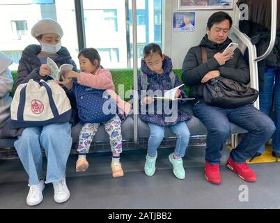 LESEN IN DER FAMILIE IN DER METRO TOKYO, JAPAN Stockfoto