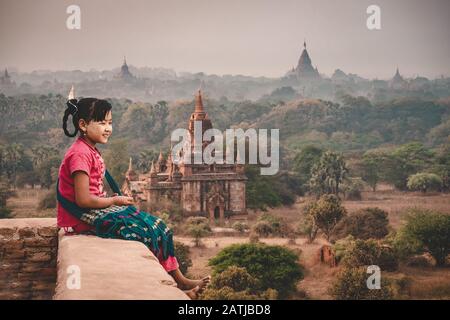 Burmesische Mädchen, Die Auf einer Pagode sitzen und die Sonne in Bagan Mandalay City Myanmar beobachten. Stockfoto