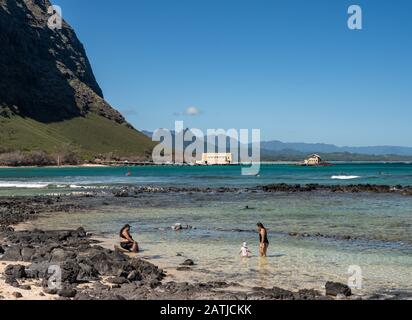 Honolulu, HI - 23. Januar 2020: Schwimmer im Gezeitenpool mit Makai Research Pier im Hintergrund auf Oahu, Hawaii Stockfoto