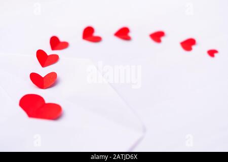 Valentinstag Hintergrundbild der roten Herzen, die aus einem Brief kommen, der auf weißem Hintergrund mit Kopierraum isoliert ist. Flaches Laienkonzept für die Liebe, weddi Stockfoto