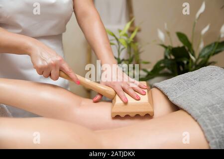 Nahaufnahme der Maderotherapie-Antizelluliti-Massage mit Holzrollenmassagegerät Stockfoto