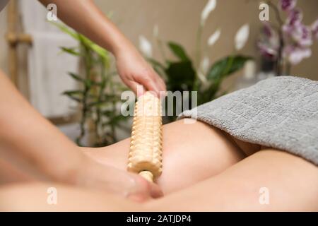 Nahaufnahme der Maderotherapie-Antizelluliti-Massage mit Holzrollenmassagegerät Stockfoto