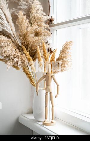 Trockenes Schilf in Keramikvase auf Fensterbank, Vintage-Heim-Innenraum Stockfoto