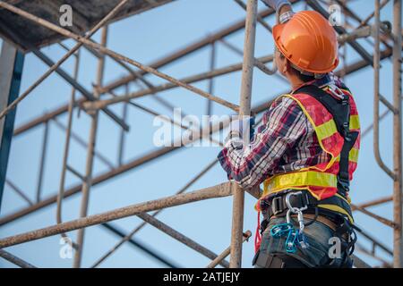 Der Arbeiter auf der Gerüstbaustelle Stockfoto