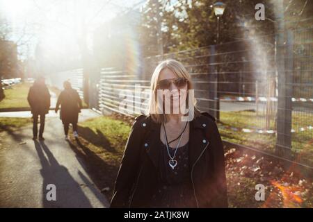 Blonde glückliche Frau auf einem Spaziergang zusammen mit ihren Freunden. Authentisches Personenporträt, Konzept 40 Jahre. Stockfoto