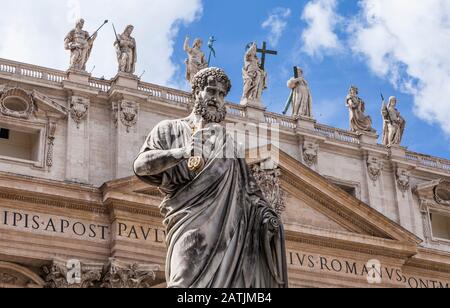 Statue des heiligen Petrus, die Schlüssel zu den Toren des Himmels mit den heiligen Statuen und der Jesusstatue hinter dem Petersplatz, der Vatikanstadt, Rom, Italien hält. Stockfoto