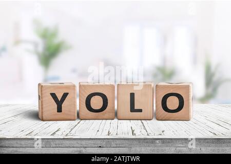 Yolo-Kürzel-Zeichen in einem hellen Wohnzimmer auf einem weißen Tisch Stockfoto