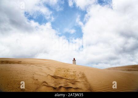 Leuchtturm inmitten einer Wüste unter blauem Himmel auf einer sandigen Düne Stockfoto