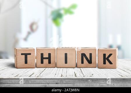 Denken Sie an ein Schild mit einer Botschaft auf einem abgenutzten Tisch in einem hellen Raum bei Tageslicht Stockfoto