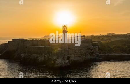 Die Sonne geht über dem Leuchtturm auf der Burg El Morro in Kuba auf. Stockfoto