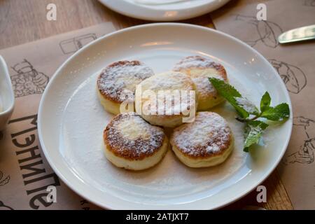 Käsekuchen mit Puderzucker und Minze Stockfoto