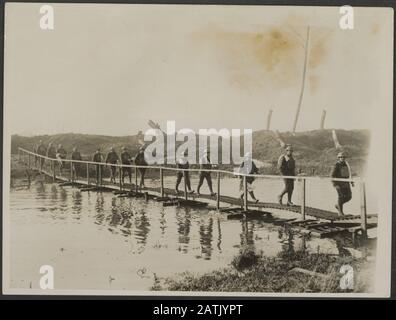 Die britische Westfront in Frankreich Beschreibung: Eine Badeparadeparty der britischen Infanterie, die nach Ihrem Bad über eine Fußgängerbrücke, die auf einer Flut von Wasser gebaut wurde, zurückkommt. Einige von ihnen tragen Ihre Handtücher Auf ihren Schultern Anmerkungen: British Western Front in Frankreich. Eine Gruppe britischer Antrymen, die von einem Bad über eine Fußgängerbrücke zurückkehren, wurde über ein überflutetes Land gebaut. Einige tragen ein Handtuch über ihre Schulter Datum: {1914-1918} Ort: Frankreich Schlagwörter: WWI, Fronten, Soldaten, Pflege, Fußbrücken Stockfoto