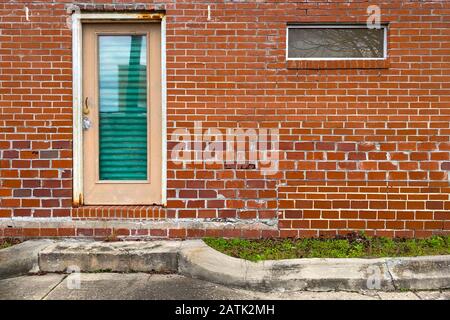 Eine rote Backstein-Lagerallee mit Büro-Hintertür Stockfoto
