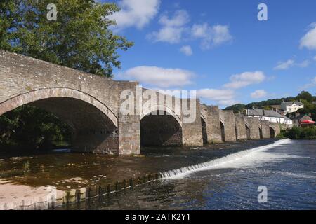 Die Klasse 1 führte eine Brücke aus dem 18. Jahrhundert auf, die über einem Wehr über den Fluss Usk, Crickhowell, Powys, Wales, Großbritannien stand Stockfoto