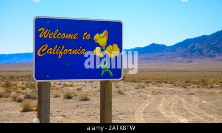 Willkommen bei California Road Sign. Wunderschöne Wüstenlandschaft mit Bergkette im Hintergrund Stockfoto