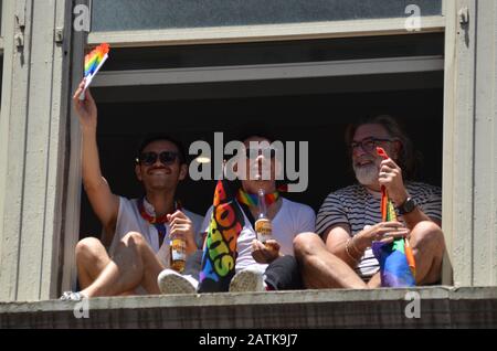 Am 30. Juni 2019 werden die Menschen auf ihrem Fenster sitzen sehen, um die bunte Pride Parade entlang der Fifth Avenue in New York City zu genießen. Stockfoto