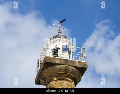 Leute, die vom Leuchtturm auf dem Whitby Pier aus blicken. England. GROSSBRITANNIEN Stockfoto