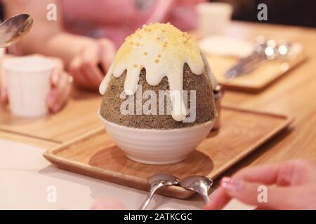 Koreanische rasiert Eis oder Schnee Kegel (bingsu oder bingsoo) Dessert, japanischer Tee Matcha gewürzt mit Kondensmilch und süßem Karamell Sirup nachfüllen. Traditio Stockfoto