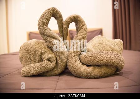 Romantisches Schlafzimmer im Inneren, Küssende Swan Origami Handtücher Dekoration auf dem Hotelzimmer Bett für frisch vermählte Paare. Hochzeit, Valentinstag, Jahrestag, Honeymoo Stockfoto