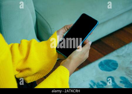 Junge Frau hält Telefon in der Hand Stockfoto