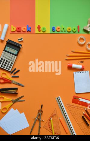 Schulbedarf auf bunten Pappen und die Worte ZURÜCK ZUR SCHULE Stockfoto