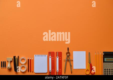 Büro- oder Schulbedarf auf orangefarbenem Karton Stockfoto