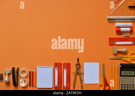 Büro- oder Schulbedarf auf orangefarbenem Karton Stockfoto