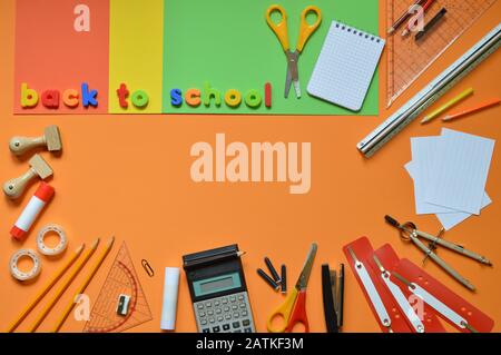 Schulbedarf auf bunten Pappen und die Worte ZURÜCK ZUR SCHULE Stockfoto