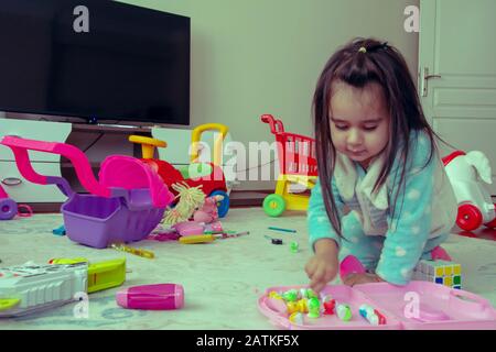 Kleine Mädchen spielen mit Spielzeug auf dem Boden Stockfoto