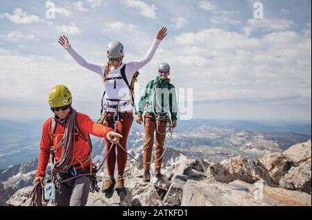 Drei Bergsteiger feiern den Gipfel des Grand Teton, Wyoming Stockfoto