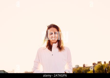 Ein hintergrundbeleuchtetes Porträt einer athletischen Frau. Stockfoto