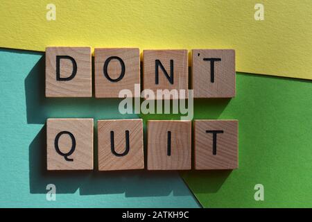 Quit nicht in 3D-Buchstaben aus Holzalphabet auf mehrfarbigem Hintergrund Stockfoto