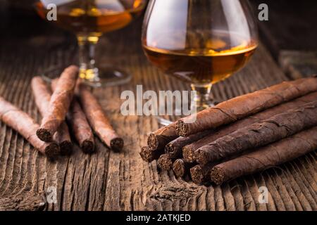 Hochwertige Zigarren und Cognac auf einem alten Holztisch Stockfoto