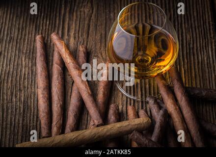 Hochwertige Zigarren und Cognac auf einem alten Holztisch Stockfoto