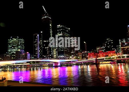 Brisbane QLD: Stadt Brisbane nachts über den Fluss. Langer Verschluss mit hellen Stadtlichtern, die auf dem Wasser reflektieren. Leuchtende Farben sind Kunst Stockfoto