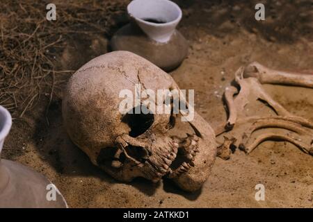 Archäologische Stätte, ein alter Menschenschädel im alten Grab Stockfoto