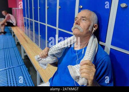 Senior man erholte sich nach dem Fitnessstudio in einem Schließfachraum Stockfoto