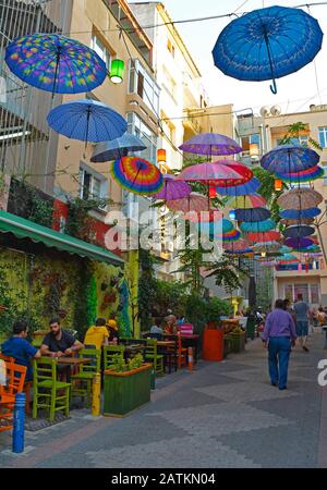 Istanbul, Türkei - 18. September 2019. Bunte Sonnenschirme hängen vom Himmel und überdecken eine Straße mit Bars und Restaurants im Moda Viertel Kadikoy Stockfoto