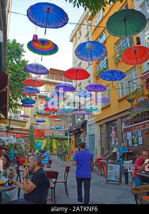 Istanbul, Türkei - 18. September 2019. Bunte Sonnenschirme hängen vom Himmel und überdecken eine Straße mit Bars und Restaurants im Moda Viertel Kadikoy Stockfoto