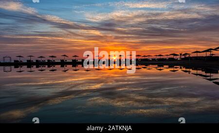 Sonnenuntergang über der Lagune mit Sonnenschirmen und liegen im Wasser, El Gouna, Ägypten, 16. Januar 2020 Stockfoto